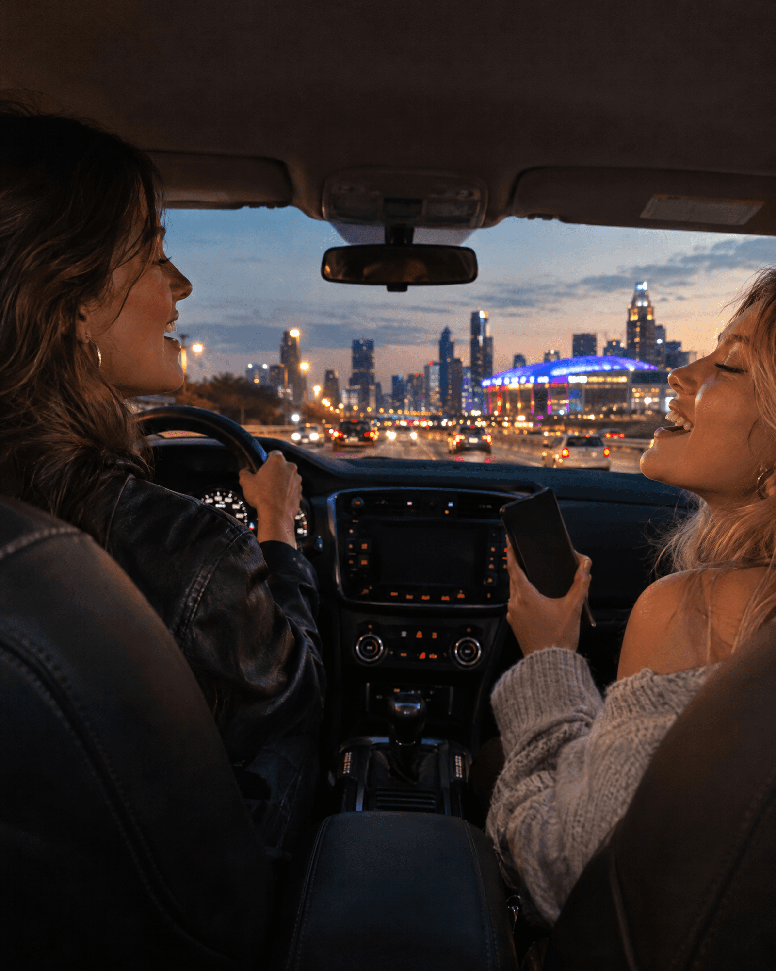 Two friends singing in a car on the way to a concert